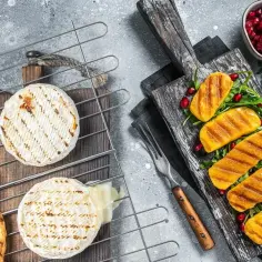 Pyszny ser na grilla, lekko roztopiony, z chrupiącymi grzankami i grillowanymi warzywami. Idealna przekąska na lato.