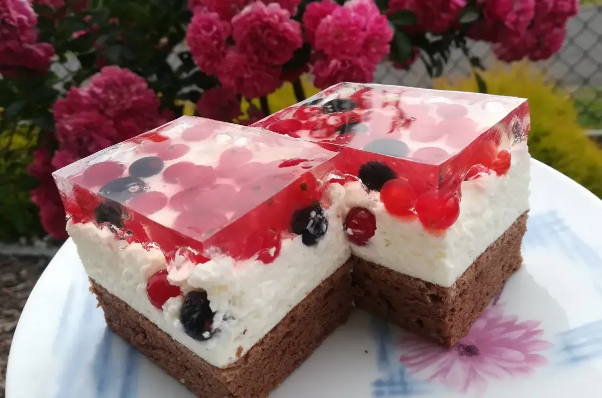 Pyszny biszkopt z galaretką i kremem mascarpone, ozdobiony owocami leśnymi. Idealny deser na letnie popołudnie.