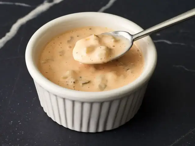 Kremowy sos amerykański z kawałkami warzyw na łyżce, w białej miseczce. Idealny do frytek!